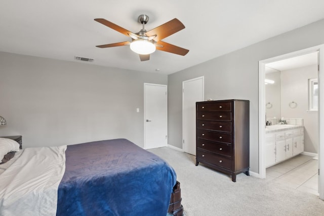 bedroom featuring light carpet, connected bathroom, sink, and ceiling fan