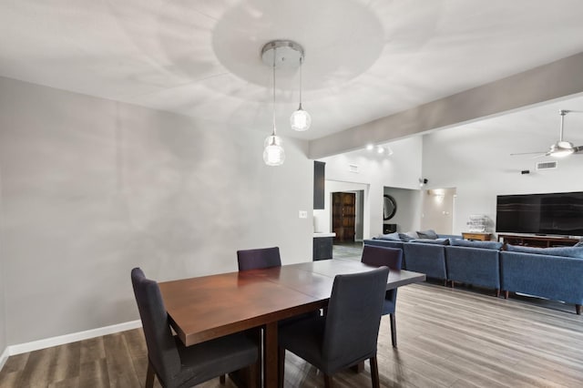 dining area with lofted ceiling with beams, wood-type flooring, and ceiling fan