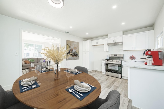 dining area with sink and light hardwood / wood-style floors