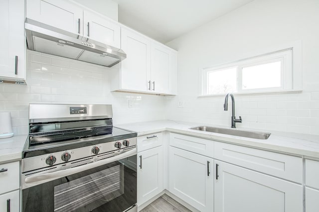 kitchen with white cabinetry, stainless steel electric range oven, sink, and light stone counters