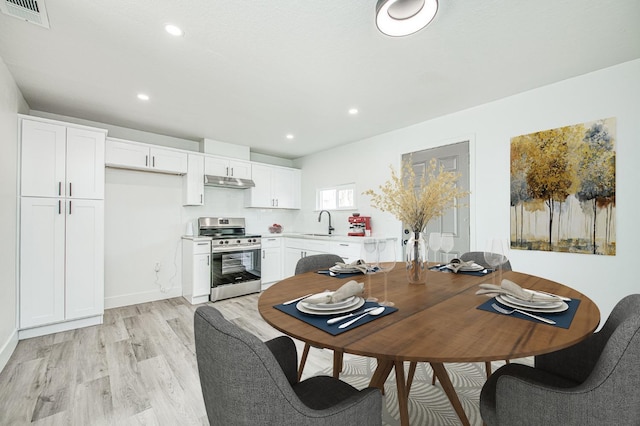 dining room with sink and light hardwood / wood-style flooring