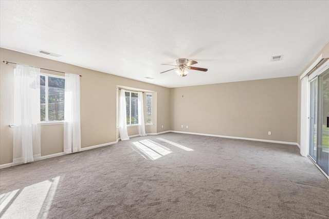 empty room featuring ceiling fan, carpet floors, and a textured ceiling