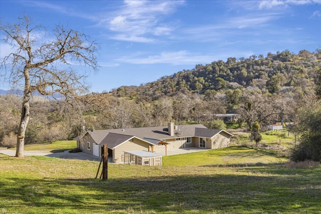 exterior space featuring a mountain view and a lawn