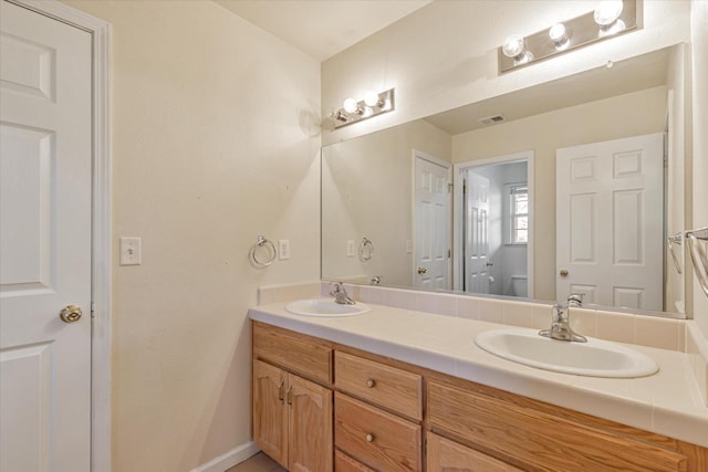 bathroom featuring vanity and toilet