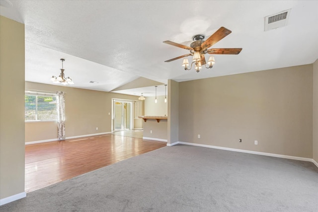 unfurnished living room featuring carpet flooring and ceiling fan with notable chandelier