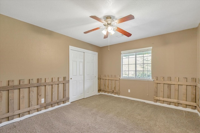 unfurnished bedroom with carpet floors, a closet, and ceiling fan