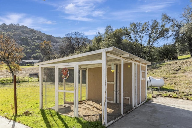 view of outdoor structure with a mountain view and a yard