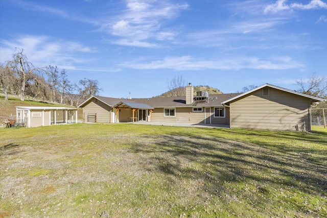 rear view of property with a shed and a lawn