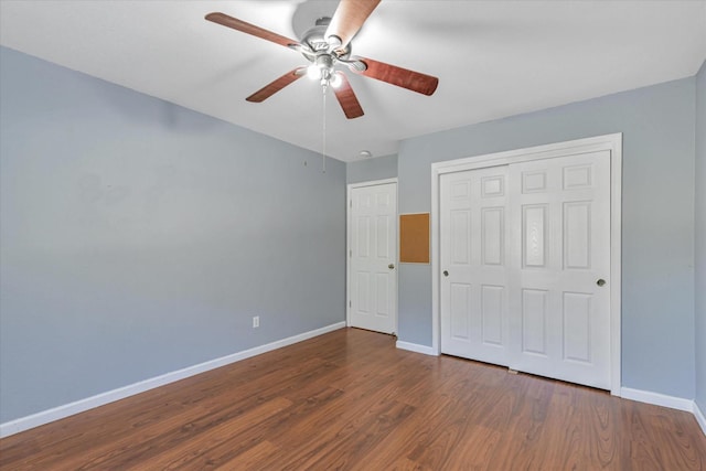 unfurnished bedroom with ceiling fan, dark hardwood / wood-style flooring, and a closet