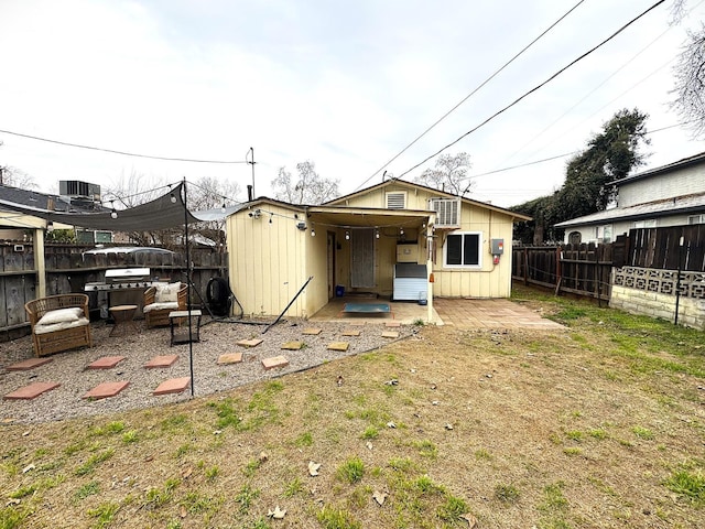 back of property with a lawn, a patio area, and central air condition unit