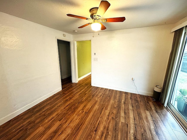 empty room featuring ceiling fan and dark hardwood / wood-style flooring