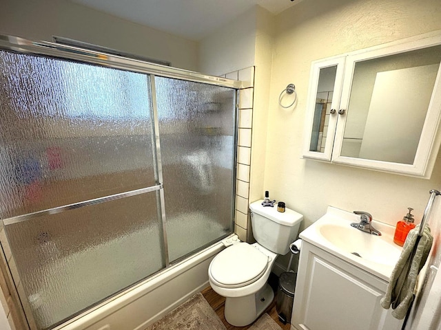 full bathroom with vanity, shower / bath combination with glass door, and toilet