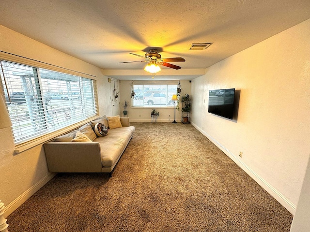 living room with ceiling fan, a textured ceiling, and carpet flooring