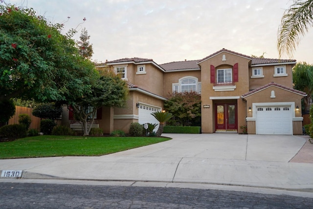 mediterranean / spanish house with a garage and a front yard