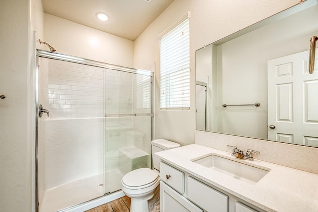 bathroom featuring vanity, toilet, a shower with door, and hardwood / wood-style floors