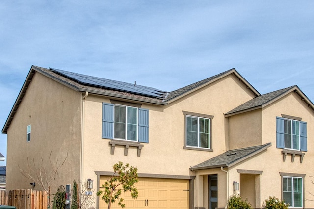 view of front of property with a garage and solar panels