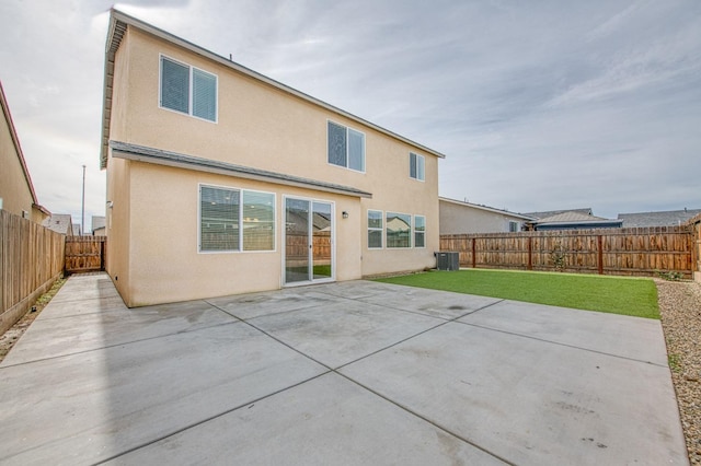 back of property with a patio, cooling unit, and a lawn