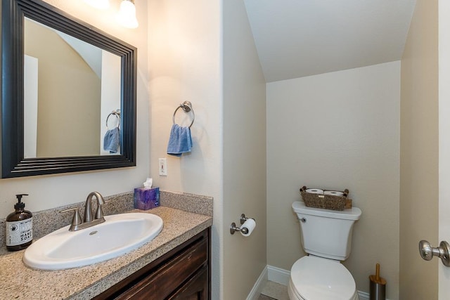 bathroom with vanity, vaulted ceiling, and toilet