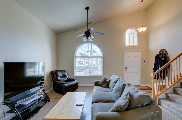 living room featuring light hardwood / wood-style flooring, high vaulted ceiling, and ceiling fan