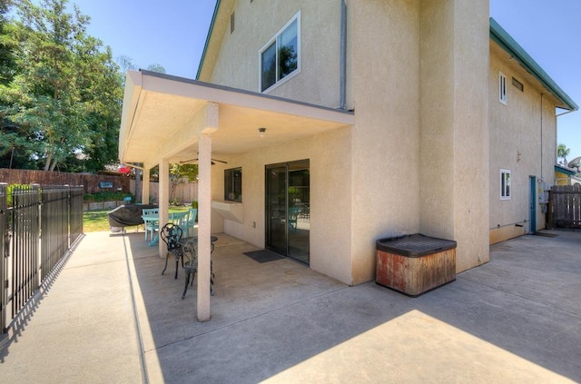 rear view of property with ceiling fan and a patio