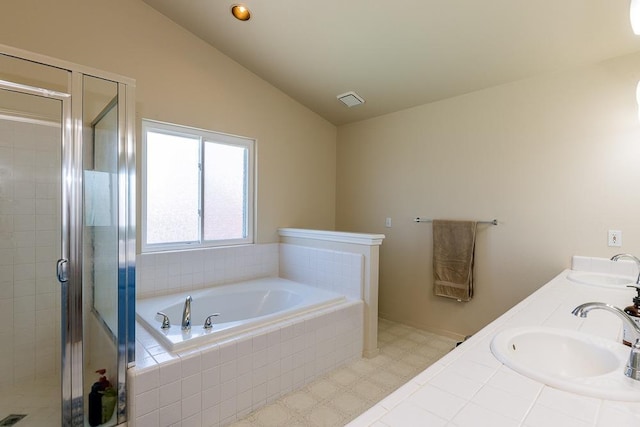 bathroom featuring independent shower and bath, vanity, and lofted ceiling