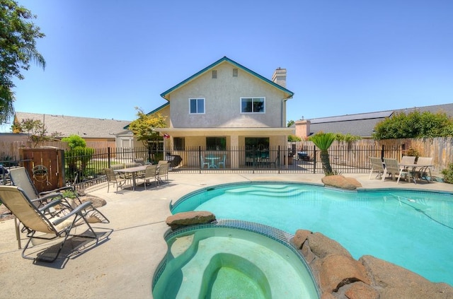 view of pool featuring an in ground hot tub and a patio