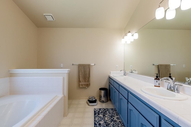 bathroom featuring vanity and tiled bath