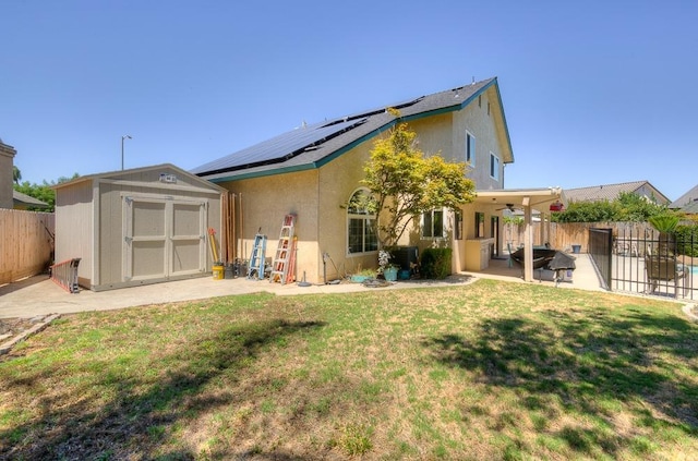 rear view of house with a storage shed, a lawn, solar panels, and a patio area