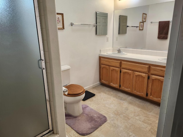 bathroom featuring vanity, toilet, and a shower with door