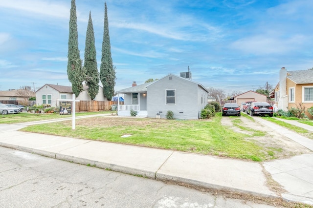 view of front of property with a garage, an outdoor structure, a front yard, and covered porch