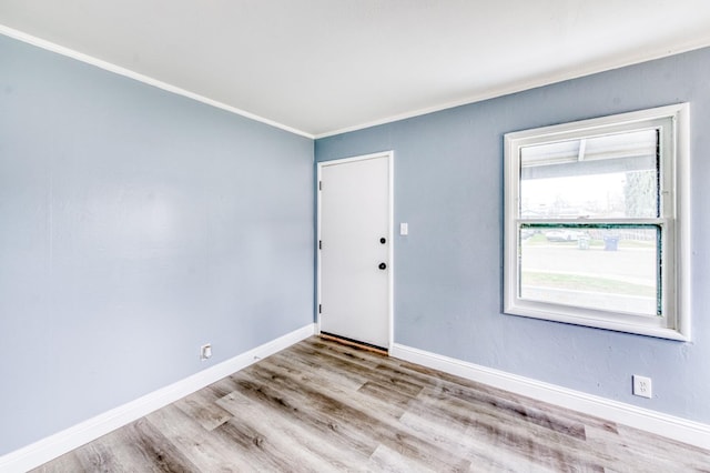 empty room with light hardwood / wood-style flooring and ornamental molding