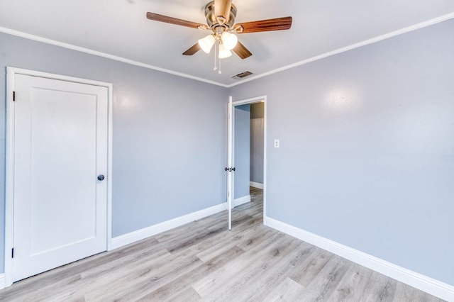 spare room featuring crown molding, ceiling fan, and light hardwood / wood-style flooring