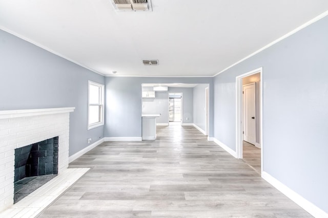 unfurnished living room with crown molding, a fireplace, and light wood-type flooring