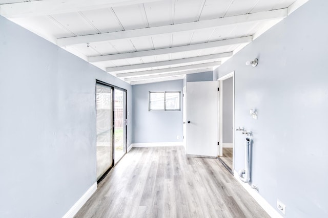 empty room with vaulted ceiling with beams and light hardwood / wood-style flooring