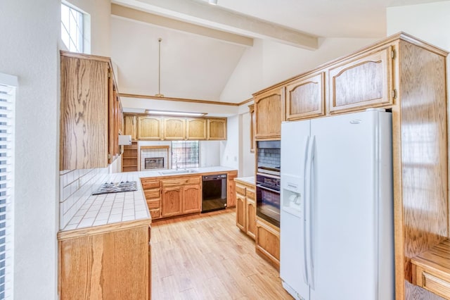 kitchen featuring vaulted ceiling with beams, light hardwood / wood-style floors, black appliances, tile countertops, and kitchen peninsula