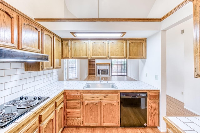 kitchen featuring tile counters, a wealth of natural light, sink, and black appliances