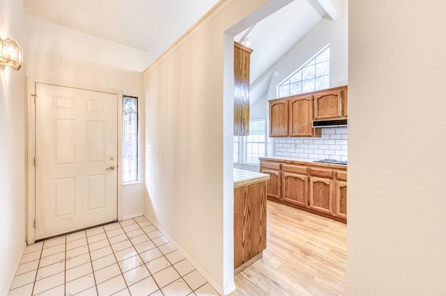 entryway with vaulted ceiling and light wood-type flooring