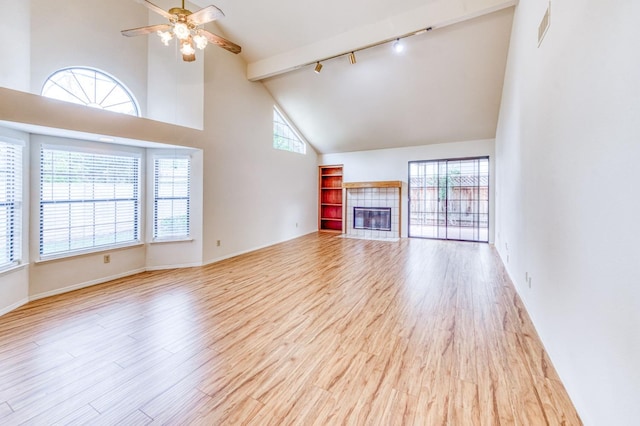 unfurnished living room featuring ceiling fan, a fireplace, high vaulted ceiling, and light wood-type flooring