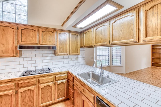 kitchen with electric stovetop, sink, tile counters, and decorative backsplash