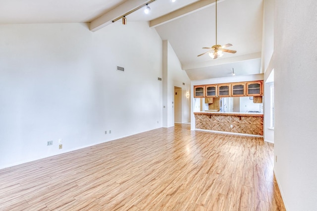 unfurnished living room featuring ceiling fan, beam ceiling, high vaulted ceiling, track lighting, and light wood-type flooring