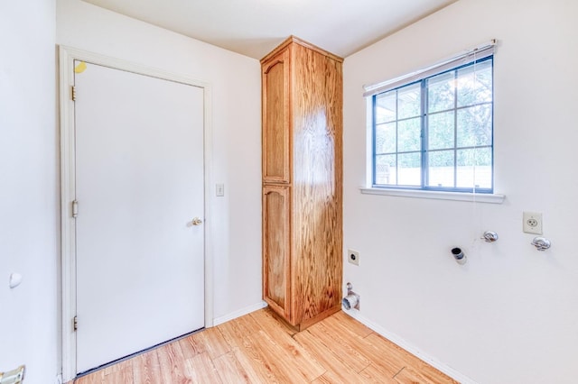 laundry area featuring gas dryer hookup, cabinets, light hardwood / wood-style flooring, and electric dryer hookup