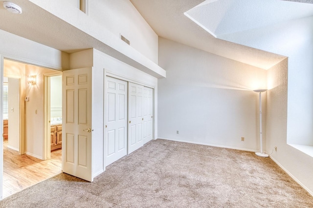 additional living space featuring vaulted ceiling and light colored carpet