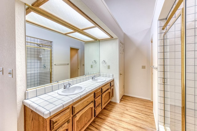 bathroom with vanity, hardwood / wood-style flooring, and a shower