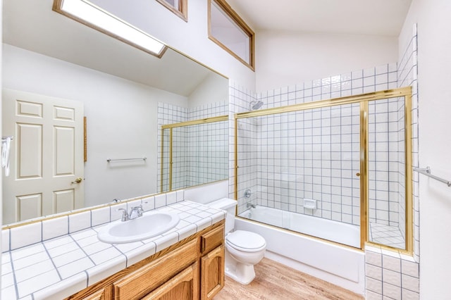 full bathroom with enclosed tub / shower combo, vanity, toilet, and vaulted ceiling