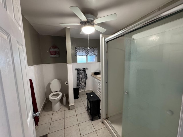 bathroom featuring toilet, an enclosed shower, vanity, ceiling fan, and tile patterned flooring