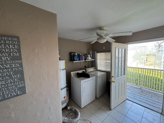 clothes washing area featuring strapped water heater, light tile patterned floors, ceiling fan, independent washer and dryer, and a textured ceiling