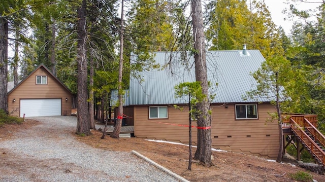 view of home's exterior featuring a garage, an outdoor structure, and a deck