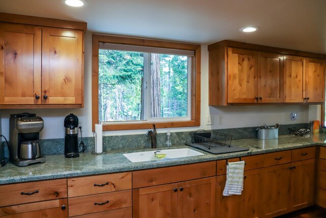 kitchen with light stone counters and sink