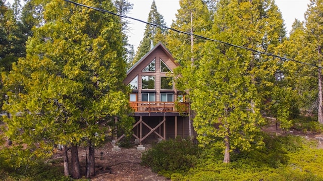 rear view of property featuring a wooden deck