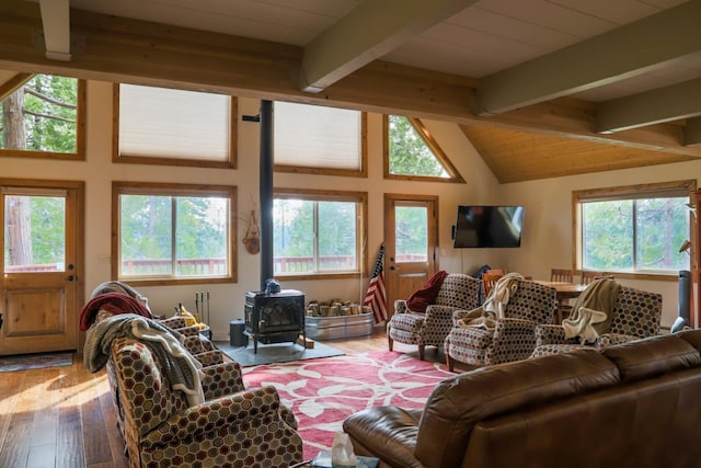 living room featuring wood-type flooring, a wood stove, vaulted ceiling with beams, and wood ceiling